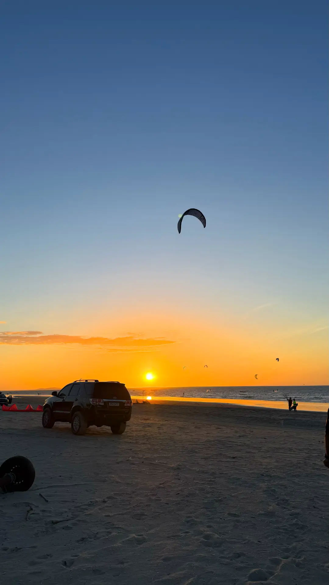 Pôr do sol sobre a praia do Preá com kitesurfistas no horizonte