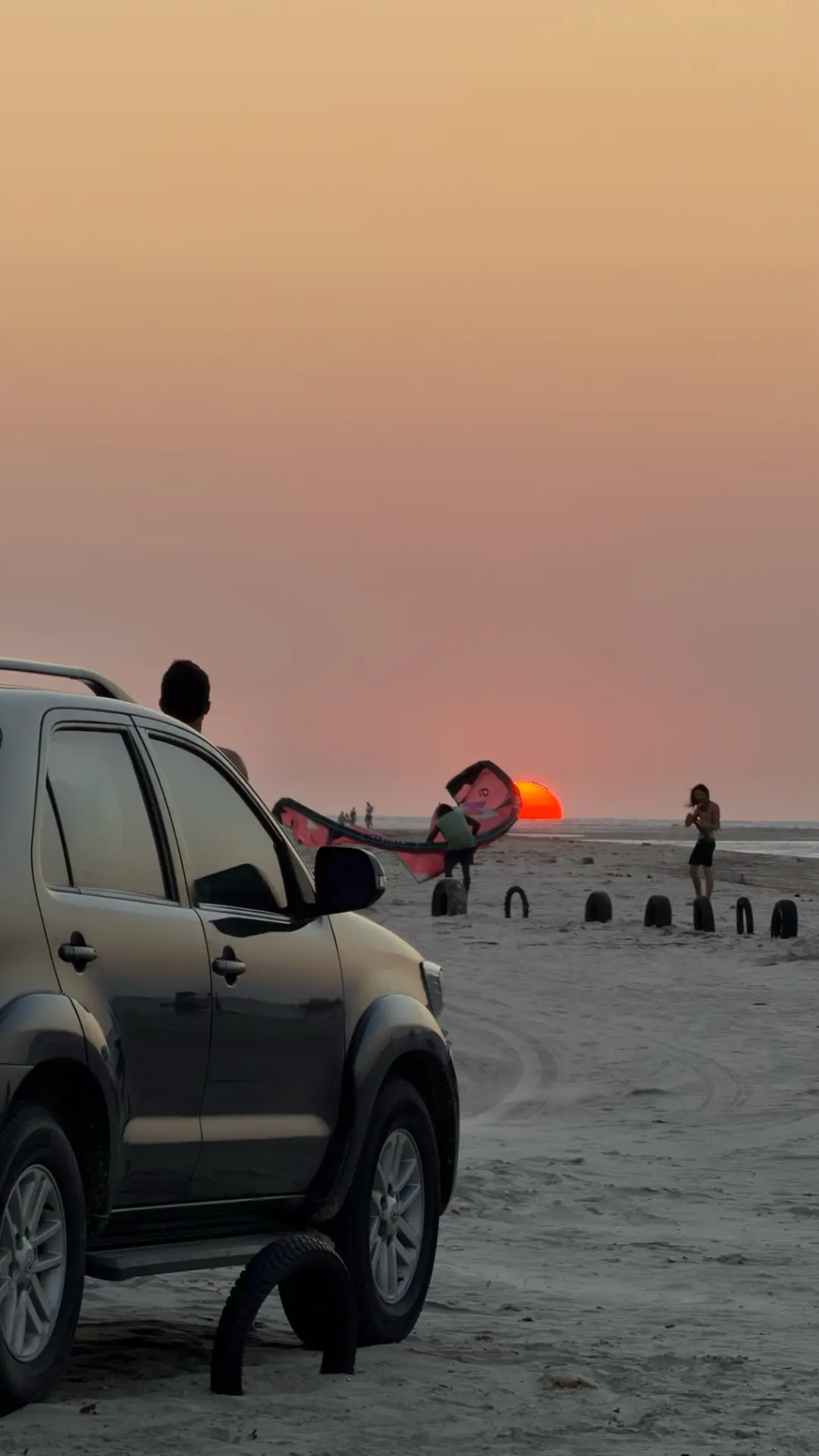 Veículo na areia durante o pôr do sol